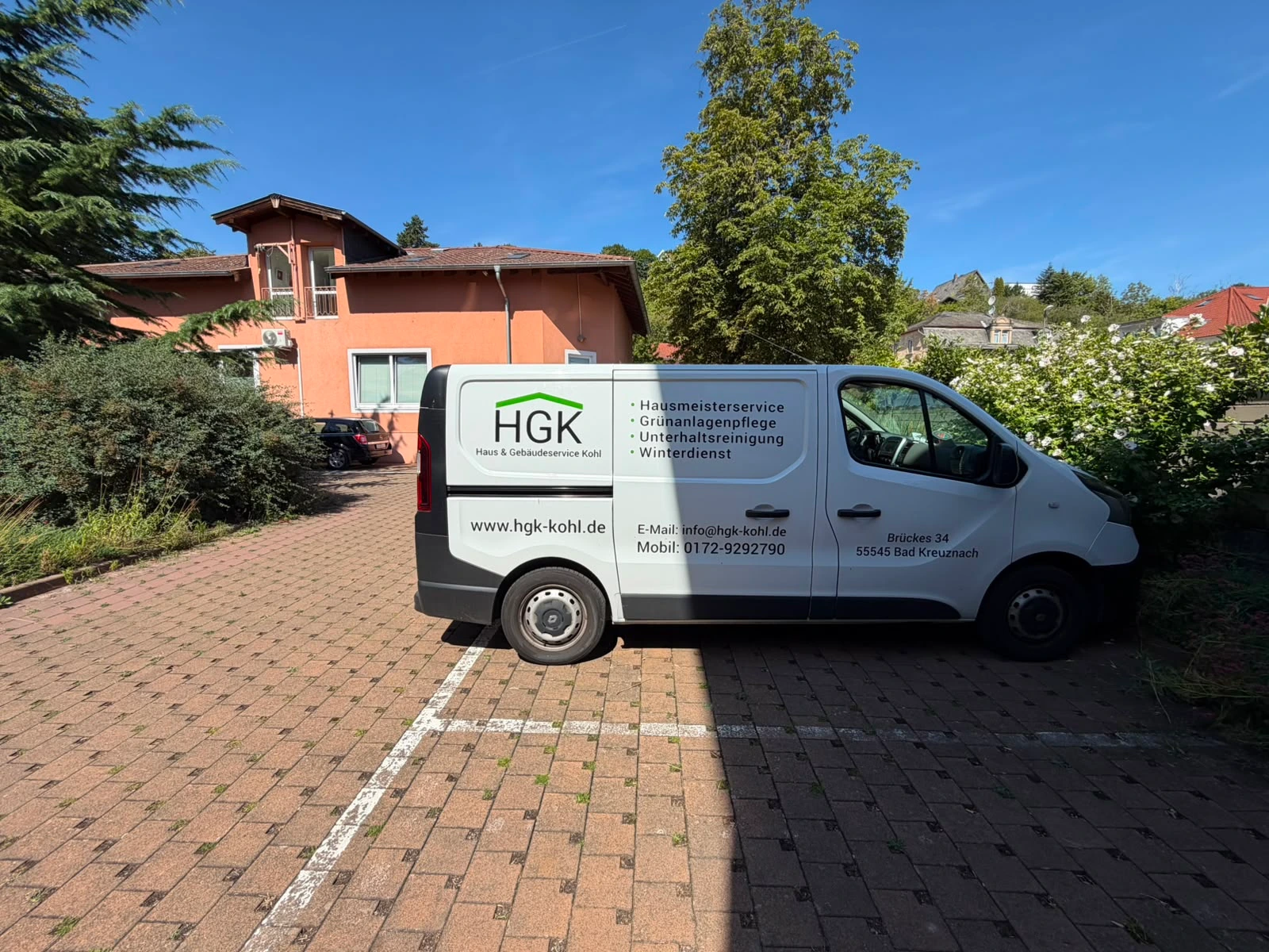 Servicefahrzeug von HGK Kohl mit Leistungsübersicht für Hausmeisterservice und Facility Management