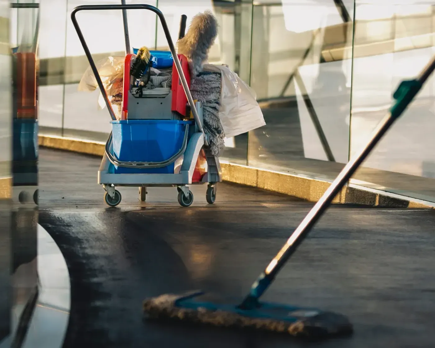 Unterhaltsreinigung mit Reinigungswagen und Wischmopp im Eingangsbereich